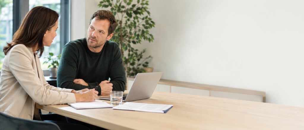 Werkgever en medewerker in gesprek aan een bureau